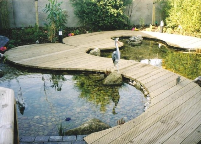 Caminhos de jardim de madeira em um jardim de estilo asiático com lago