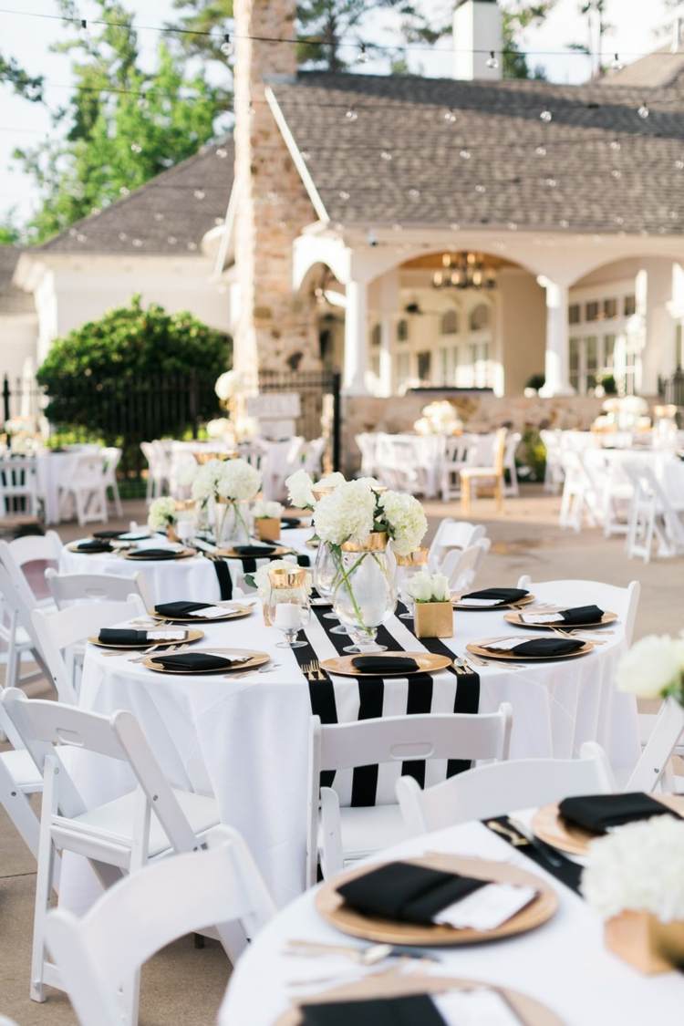 Mesas de casamento em preto e branco com listras corrediças e detalhes em placa de ouro