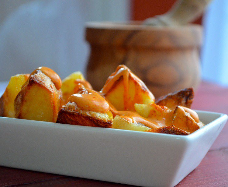 preparando receitas de tapas patates bravas com batata e molho de tomate quente