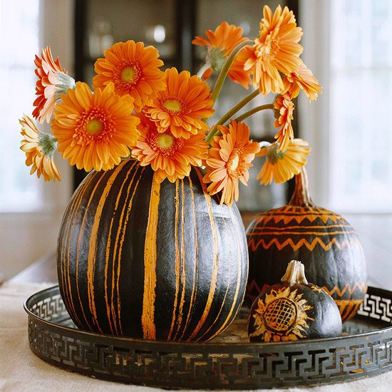 Decoração entalhada de abóboras coloridas na mesa de noite de Halloween