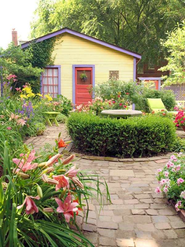 jardim galpão com porta vermelha solo-pedra floração-tipos de plantas perenes sebes