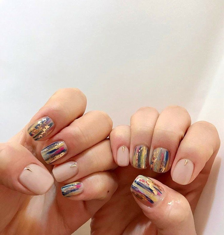 Unhas de gel com folha de ouro com toques de cor nude