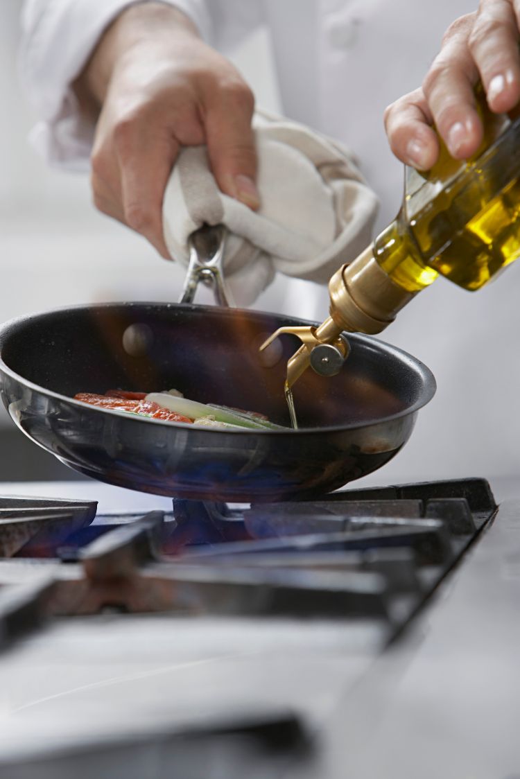 Pegue azeite de oliva para fritar a frigideira de vidro despeje a placa de fogão a gás para cozinhar legumes