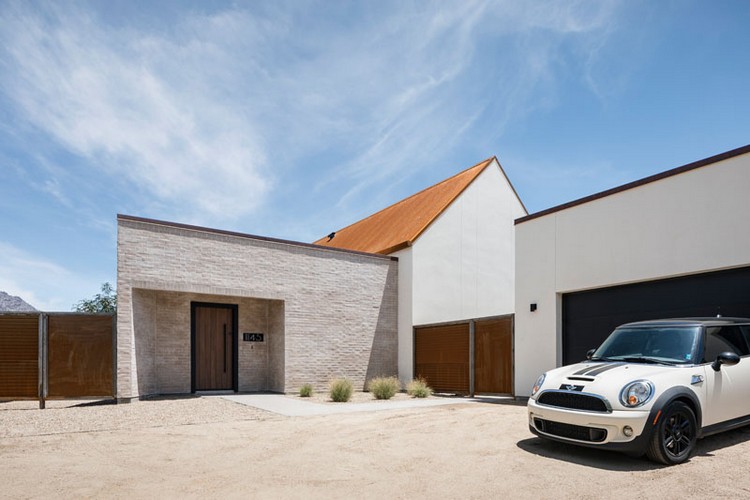 casa fachada de concreto branco fachada de tijolos telhado de metal enferrujado