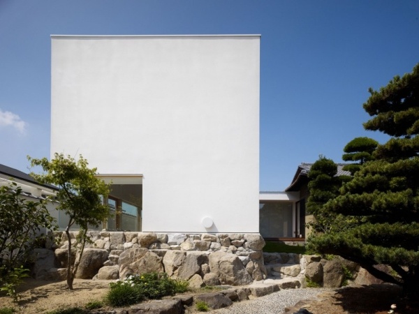 casa no jardim construída em torno de uma árvore vista lateral de pedras