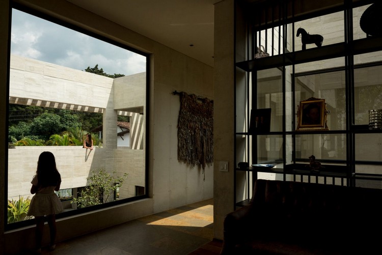 vista de dentro para fora da janela quadrada da casa com jardim