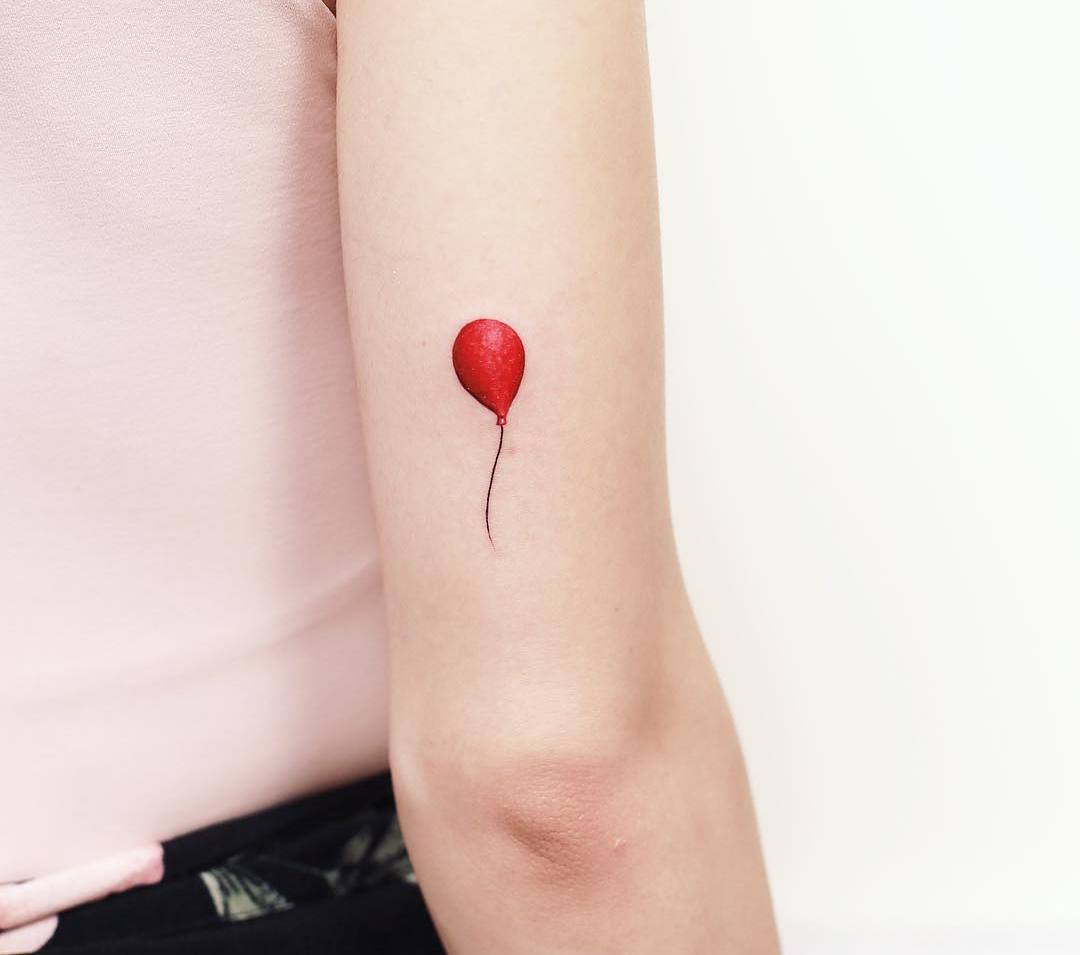 Mini tatuagem de balão vermelho na parte de trás do braço