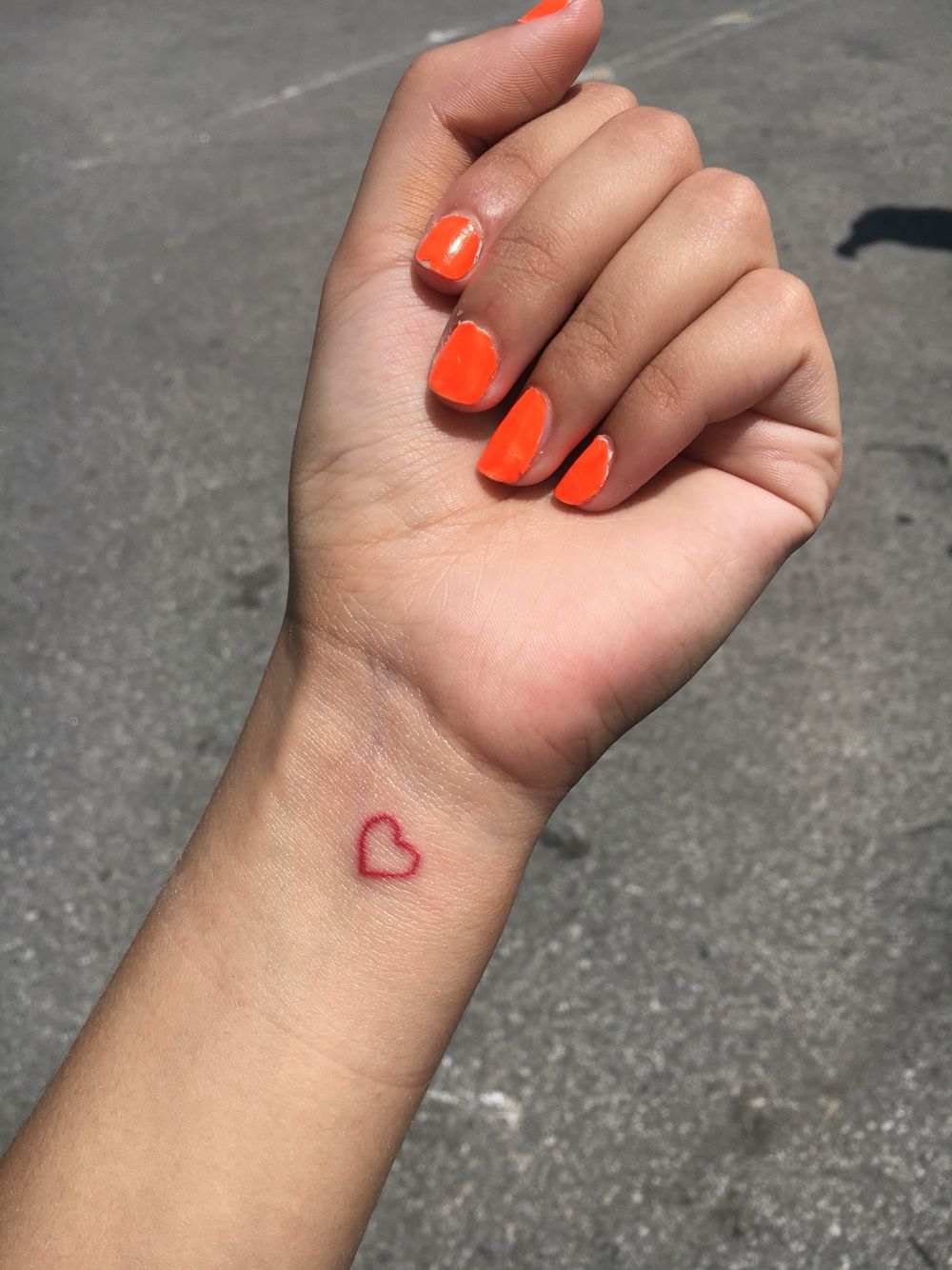 Pequenas tatuagens vermelhas com uma ideia para um coração no pulso