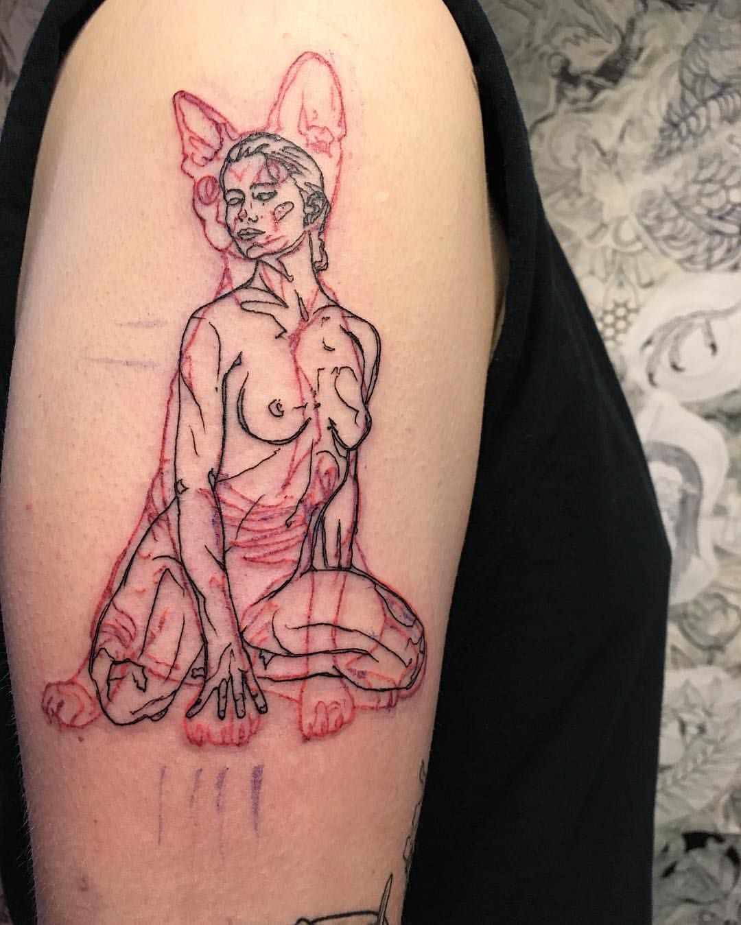 Tatuagens pretas e vermelhas combinam - mulher nua com gato ao fundo