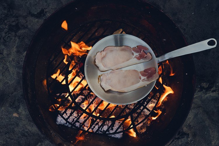 Comida de festa ocidental com bacon na frigideira de ferro na grelha